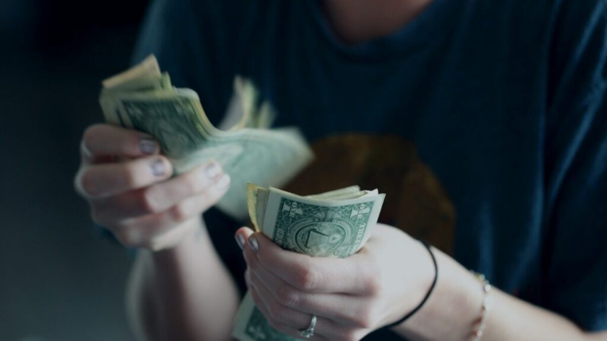 focus photography of person counting dollar banknotes