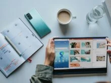person using Windows 11 computer beside white ceramic mug on white table