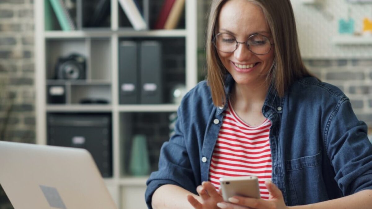 a woman sitting at a table looking at her cell phone