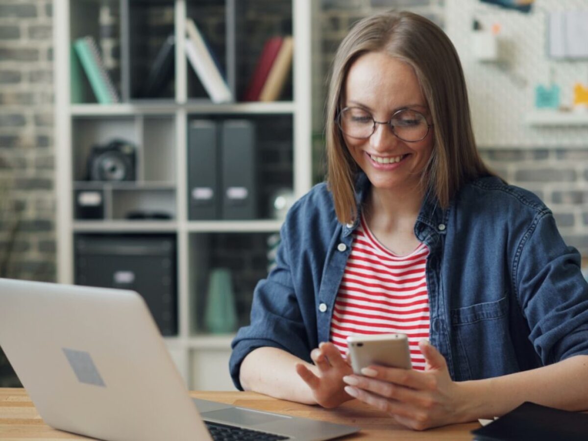 a woman sitting at a table looking at her cell phone