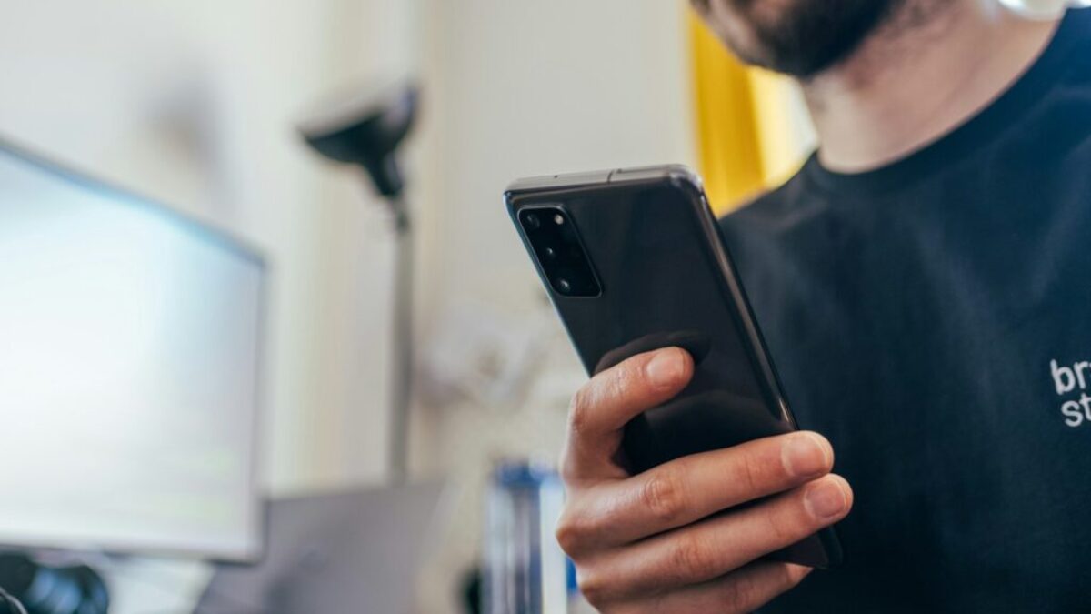 man in black crew neck shirt holding black iphone 5