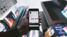 high angle photo of person holding turned on smartphone with tall buildings background