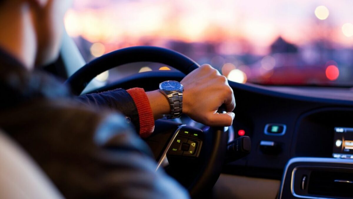man driving a car wearing wrist watch