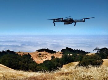 black drone on air over cloudy sky at daytime