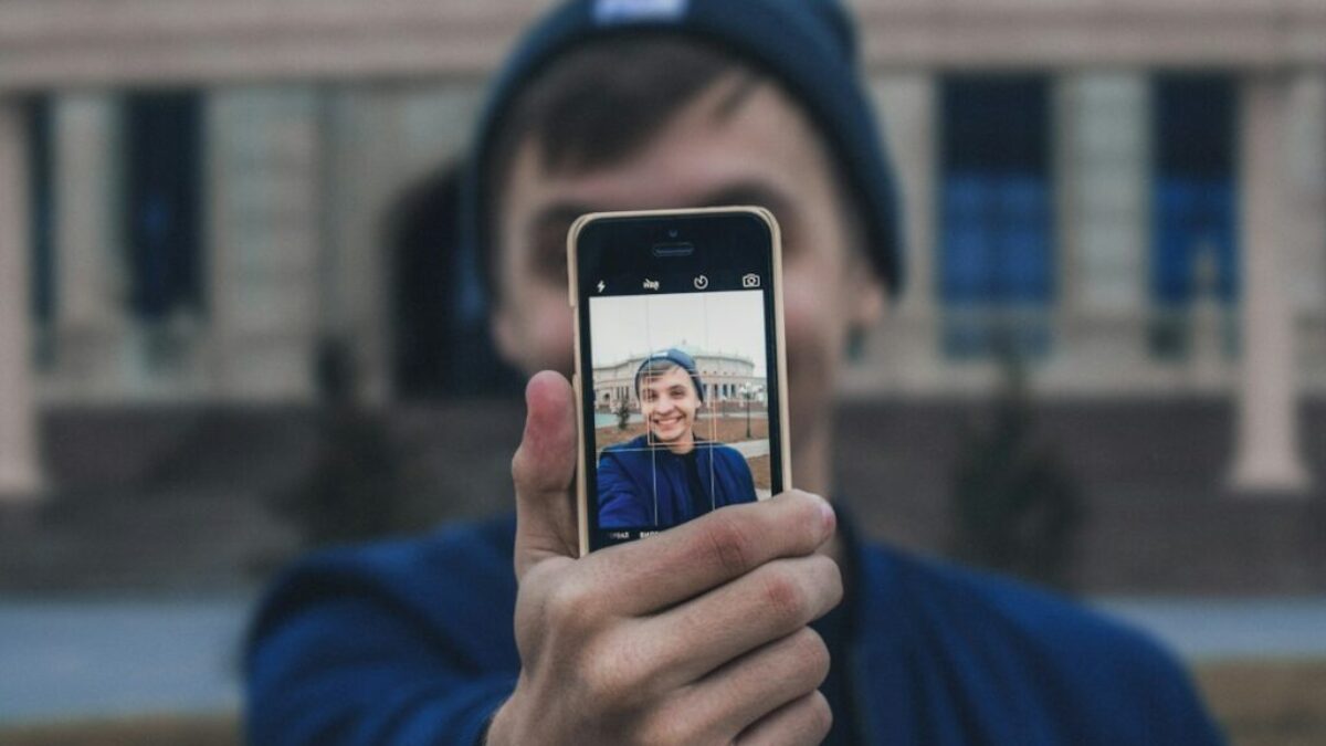 man taking photo near building