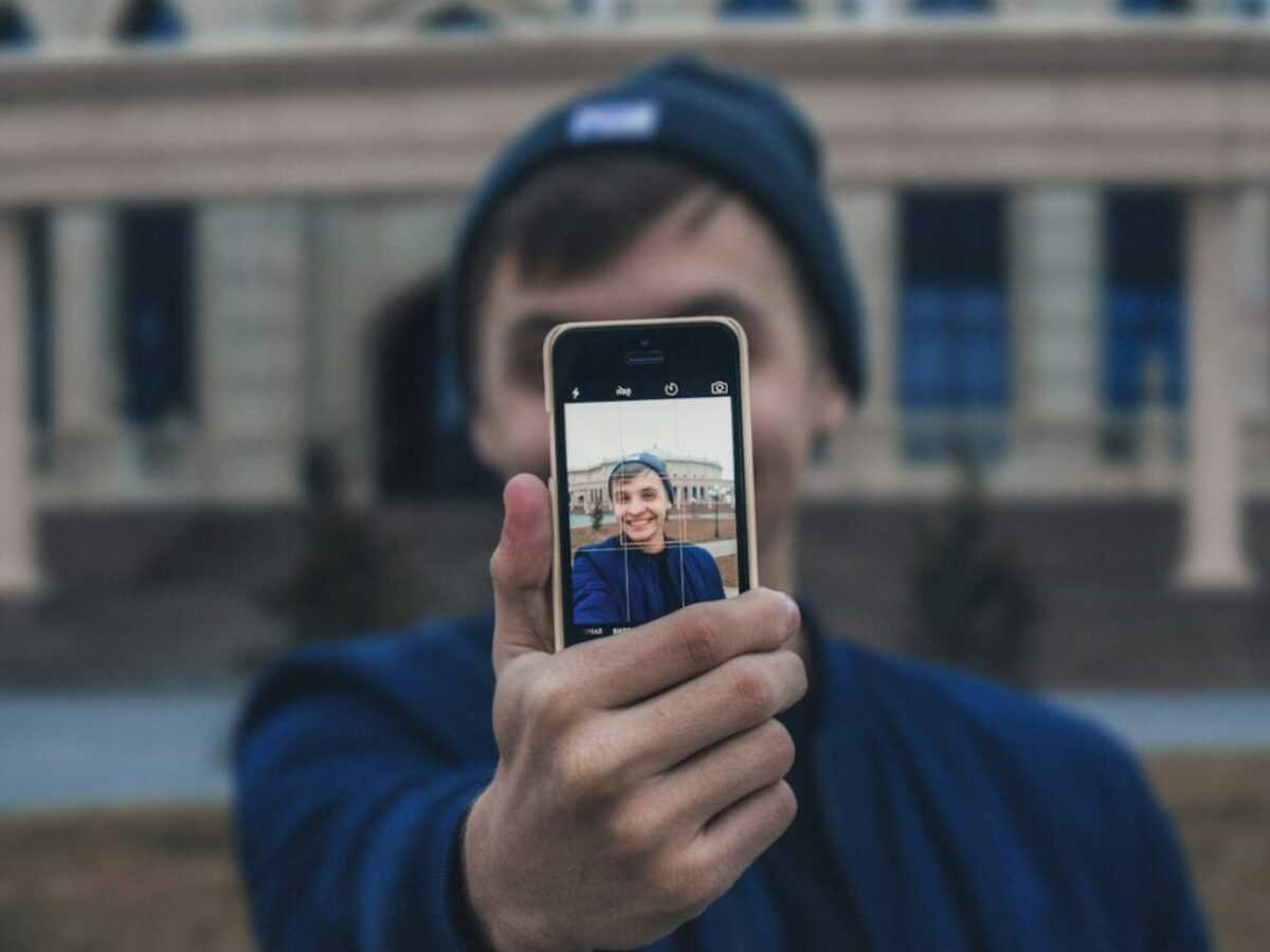 man taking photo near building