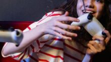 A Woman in Striped Shirt Holding a Game Controller