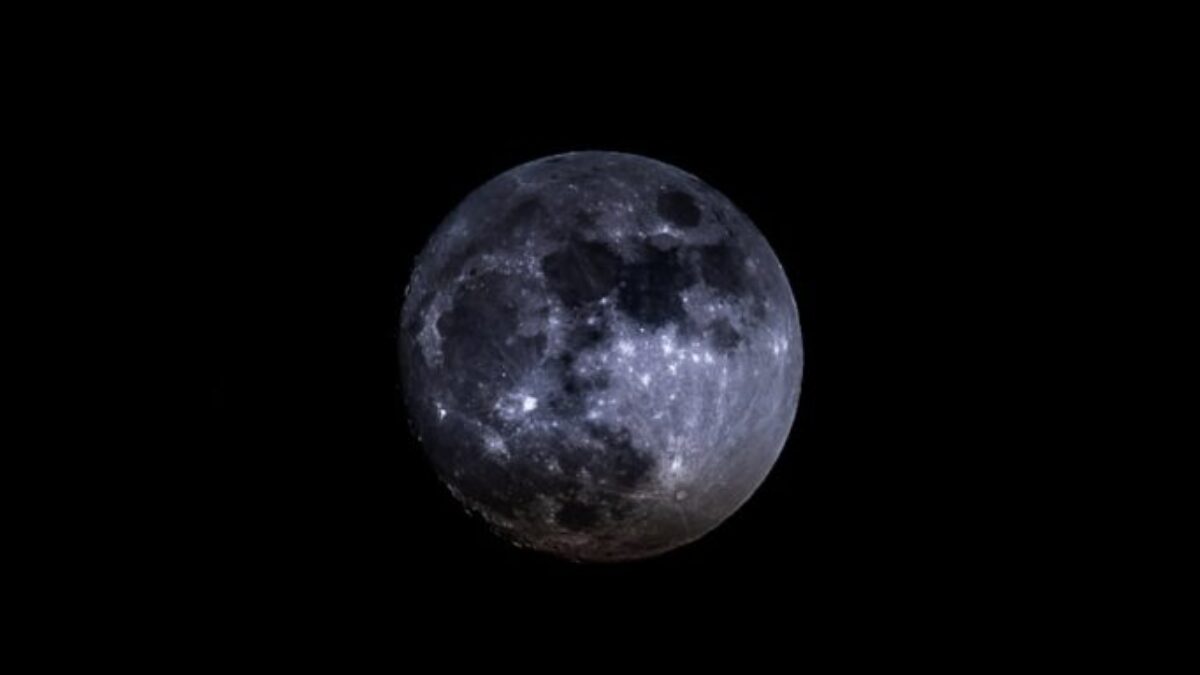 a full moon is seen in the dark sky