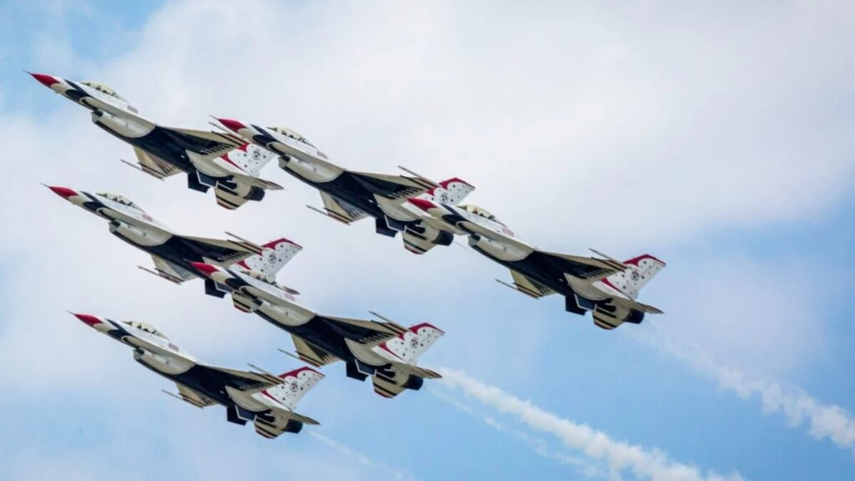 a group of fighter jets flying through a blue sky