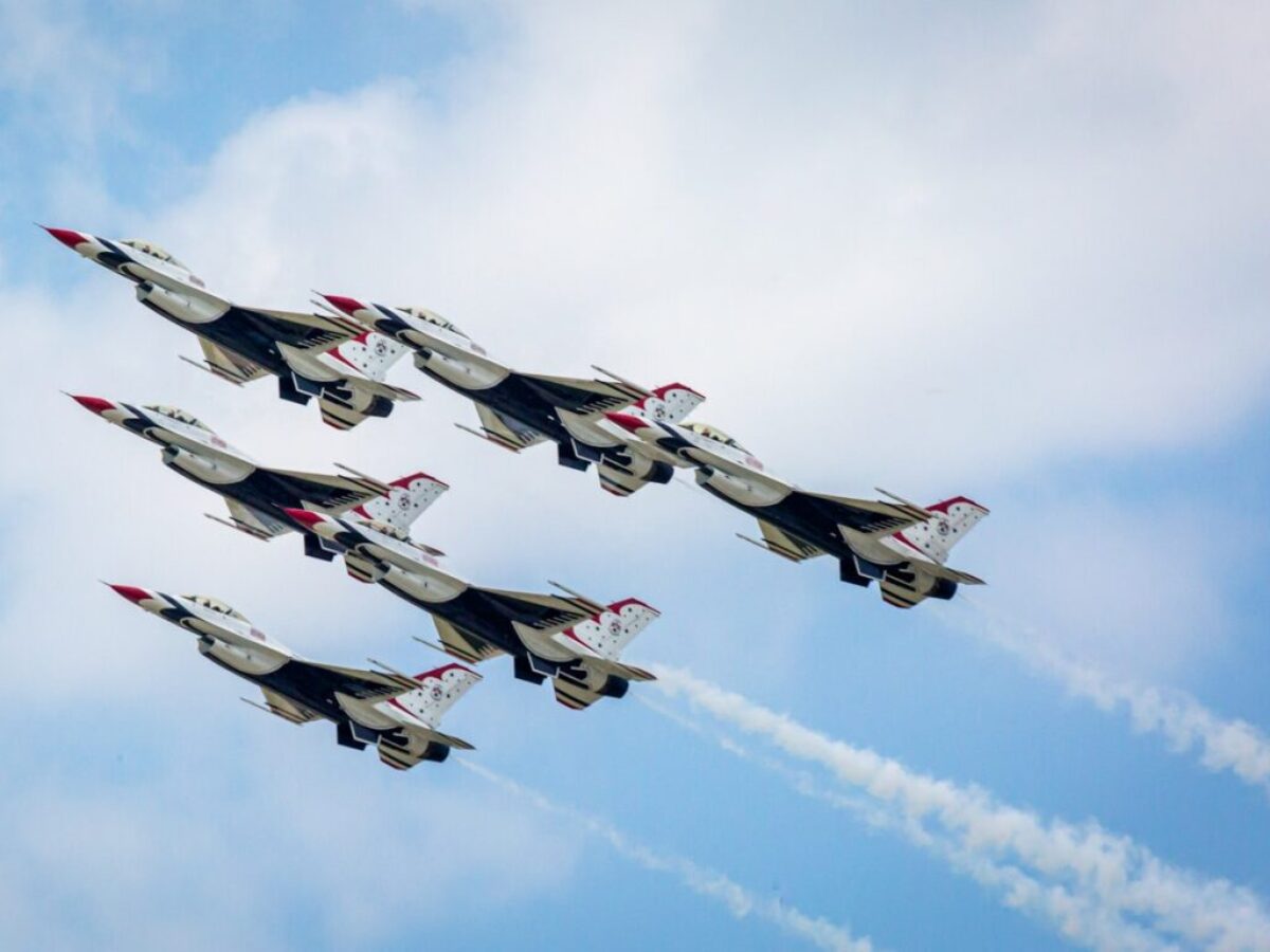a group of fighter jets flying through a blue sky