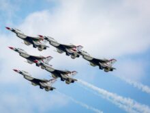 a group of fighter jets flying through a blue sky