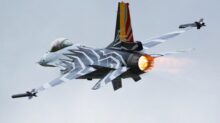 a fighter jet flying through a cloudy sky