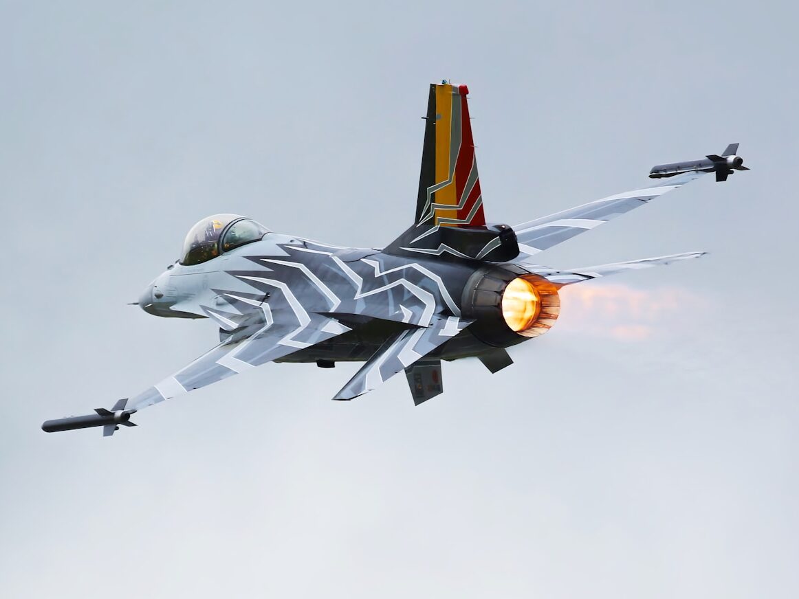 a fighter jet flying through a cloudy sky