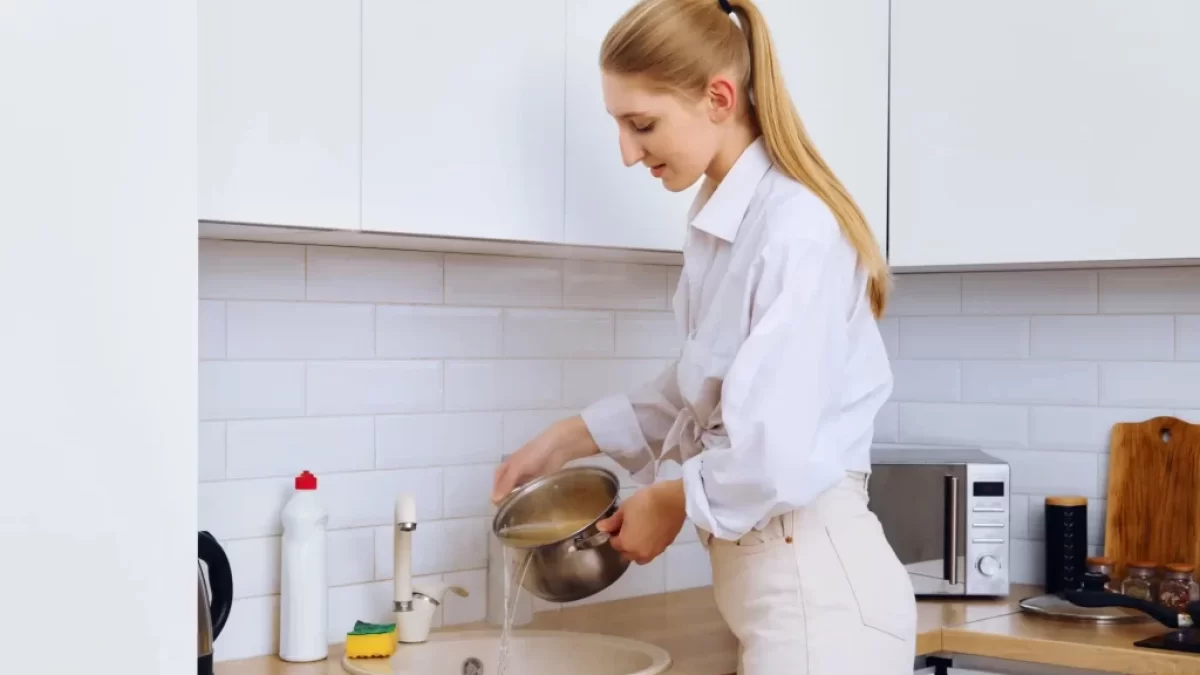 Žena vylévá vodu z těstovin