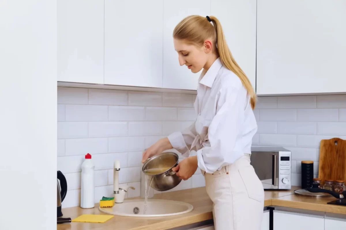 Žena vylévá vodu z těstovin