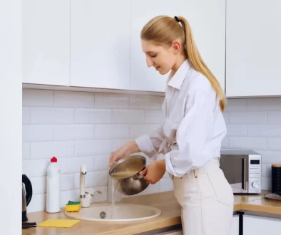 Žena vylévá vodu z těstovin