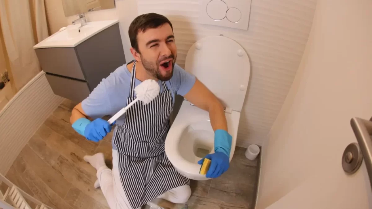 Muž čistící toaletu