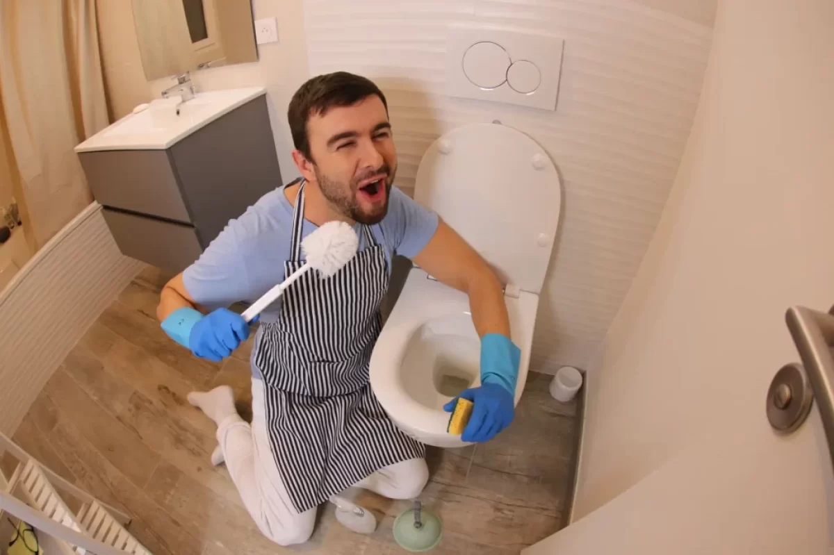 Muž čistící toaletu