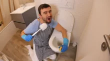 Muž čistící toaletu