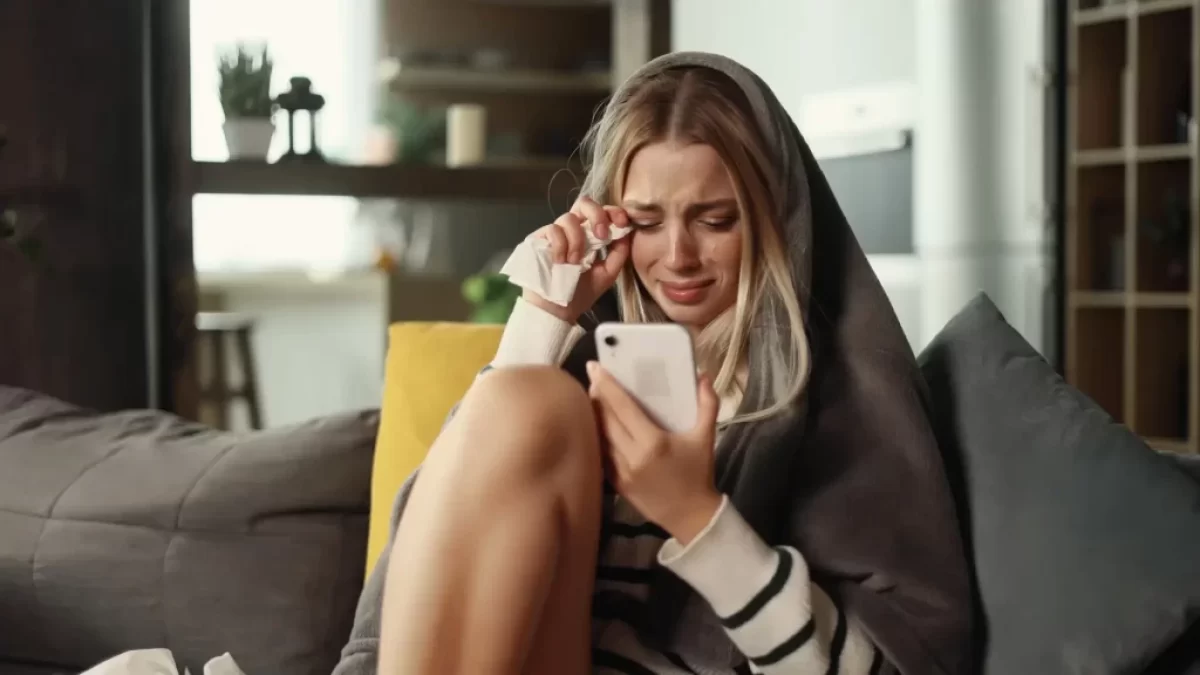 Smutná žena s mobilem v ruce