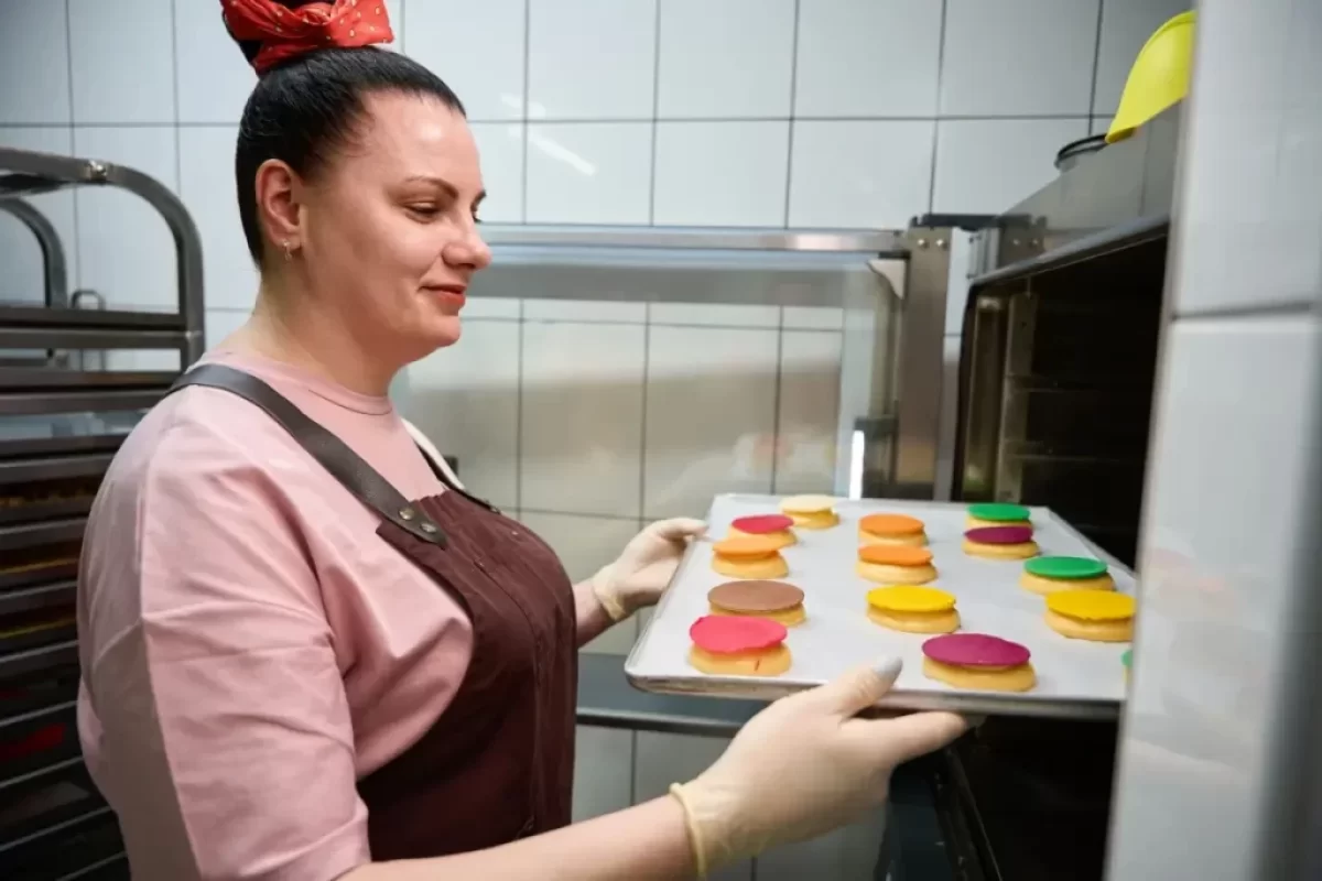 Žena vkládá pečivo do trouby