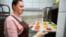 Žena vkládá pečivo do trouby