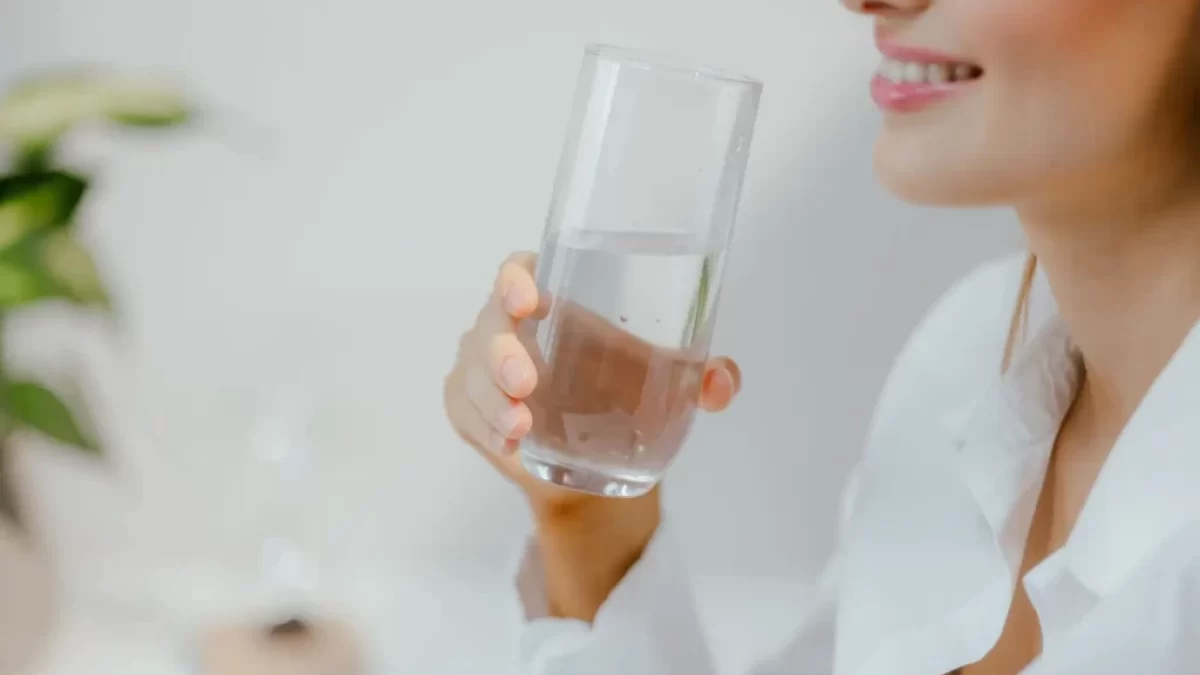 Usměvavá žena se sklenicí vody