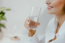 Usměvavá žena se sklenicí vody