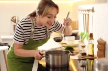 žena vaří kuřecí polévku