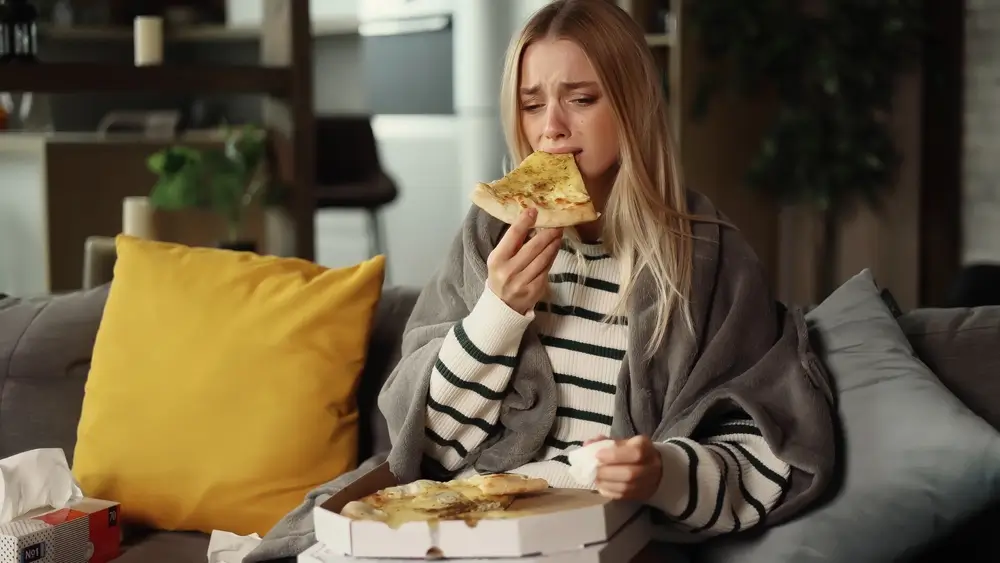 shutterstock_2277209683 - Techsvět Dívka ve stresu jí pizzu