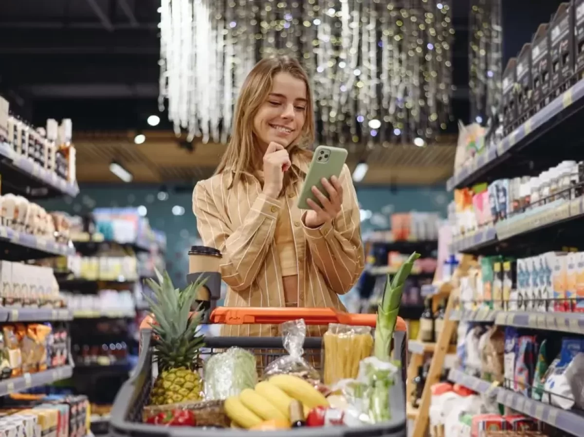 Žena nakupuje s mobilem v ruce