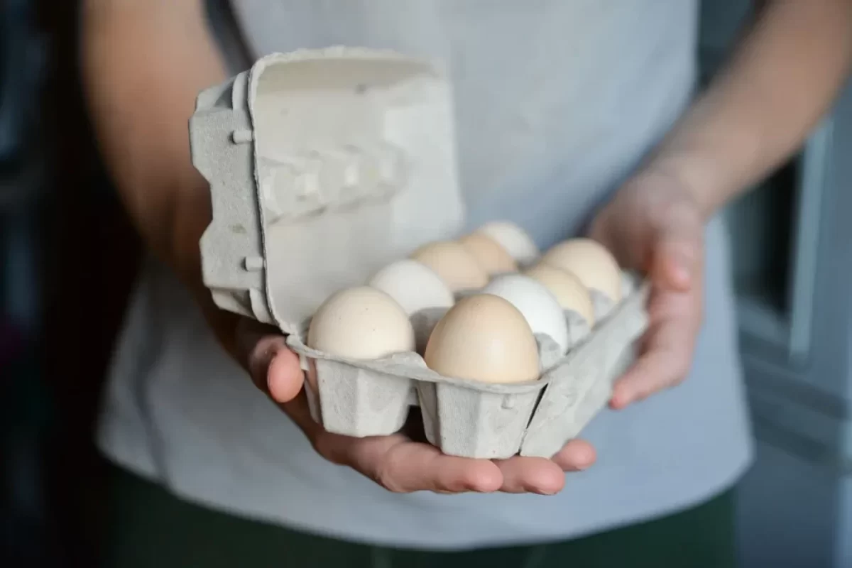 Muž drží plato s vejci.