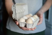 Muž drží plato s vejci.