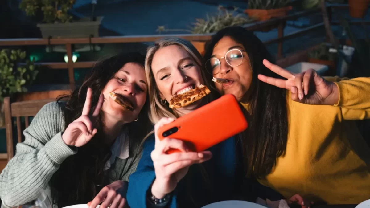 Ženy si užívají konzumaci pizzy.