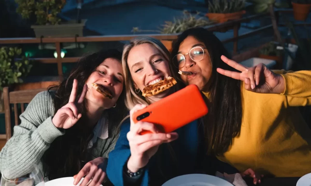 Ženy si užívají konzumaci pizzy.