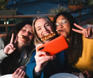 Ženy si užívají konzumaci pizzy.