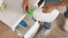 Muž nalévá prací gel do pračky