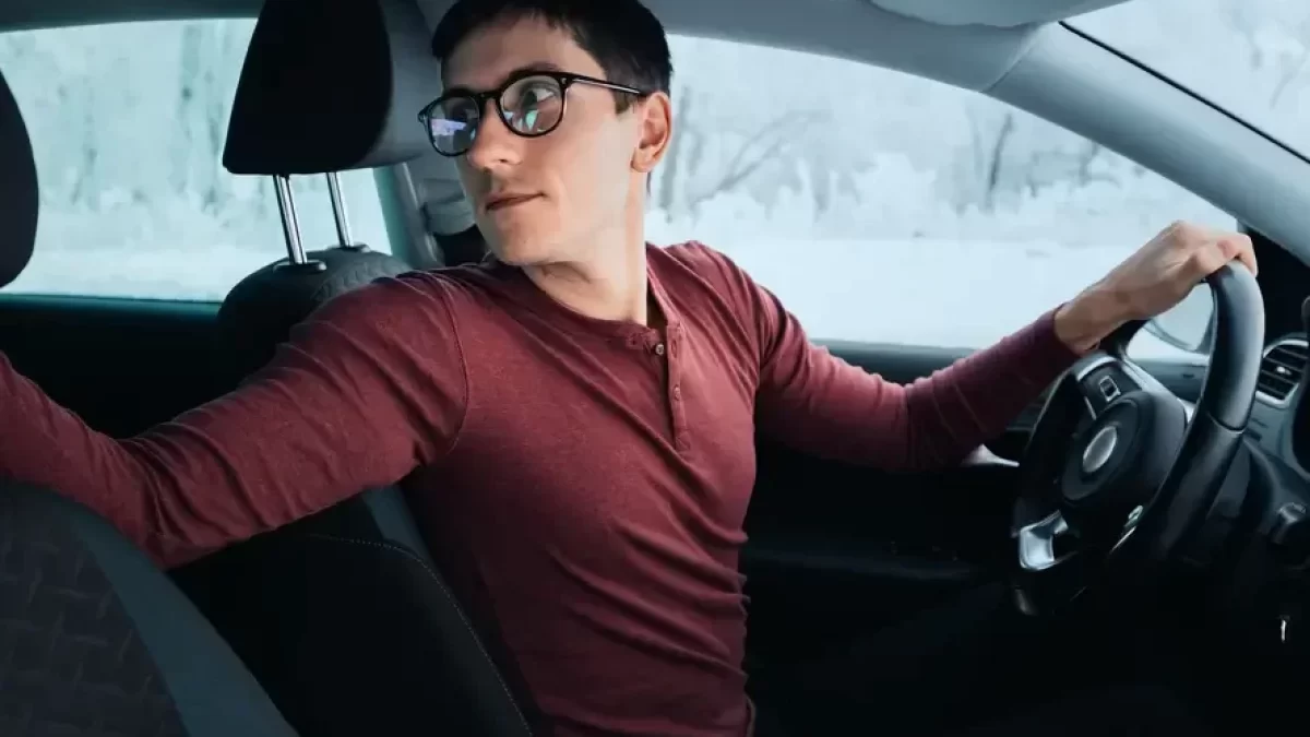 Muž couvá v autě.