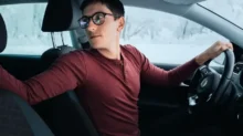 Muž couvá v autě.