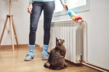 žena utírá prach na topení
