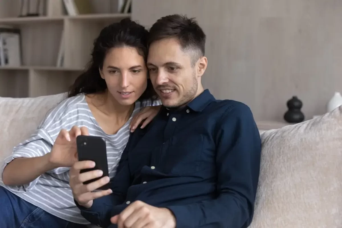 Pár spolu kouká do mobilu