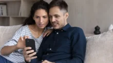 Pár spolu kouká do mobilu