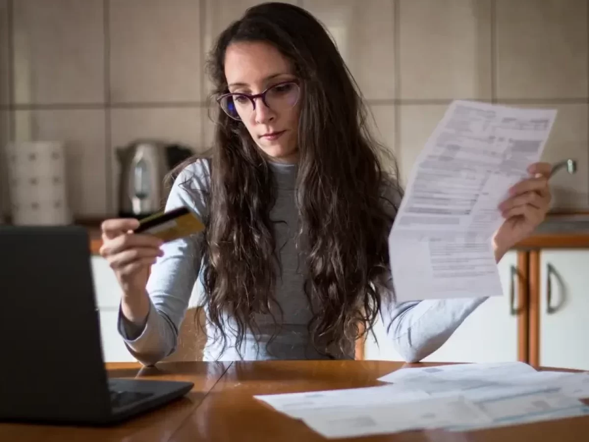 Žena prohlížející si platební kartu.