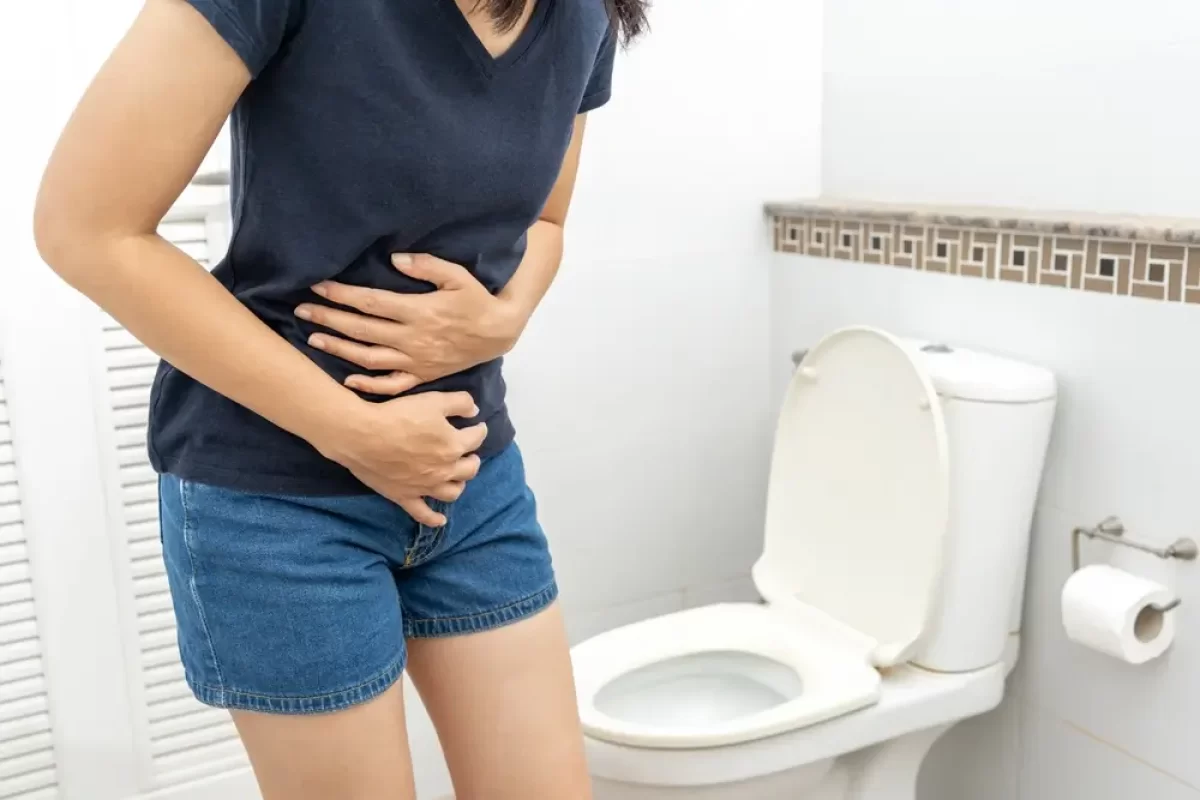 Žena s bolestmi břicha u toalety