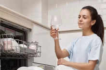 žena vytahuje skleničku z myčky