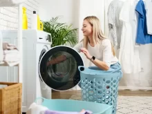 Žena vytahuje prádlo z pračky.