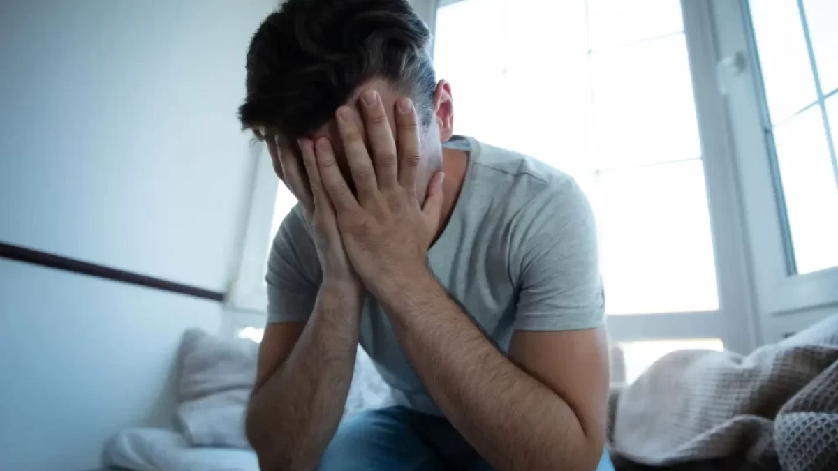 Sklíčený muž v depresi.