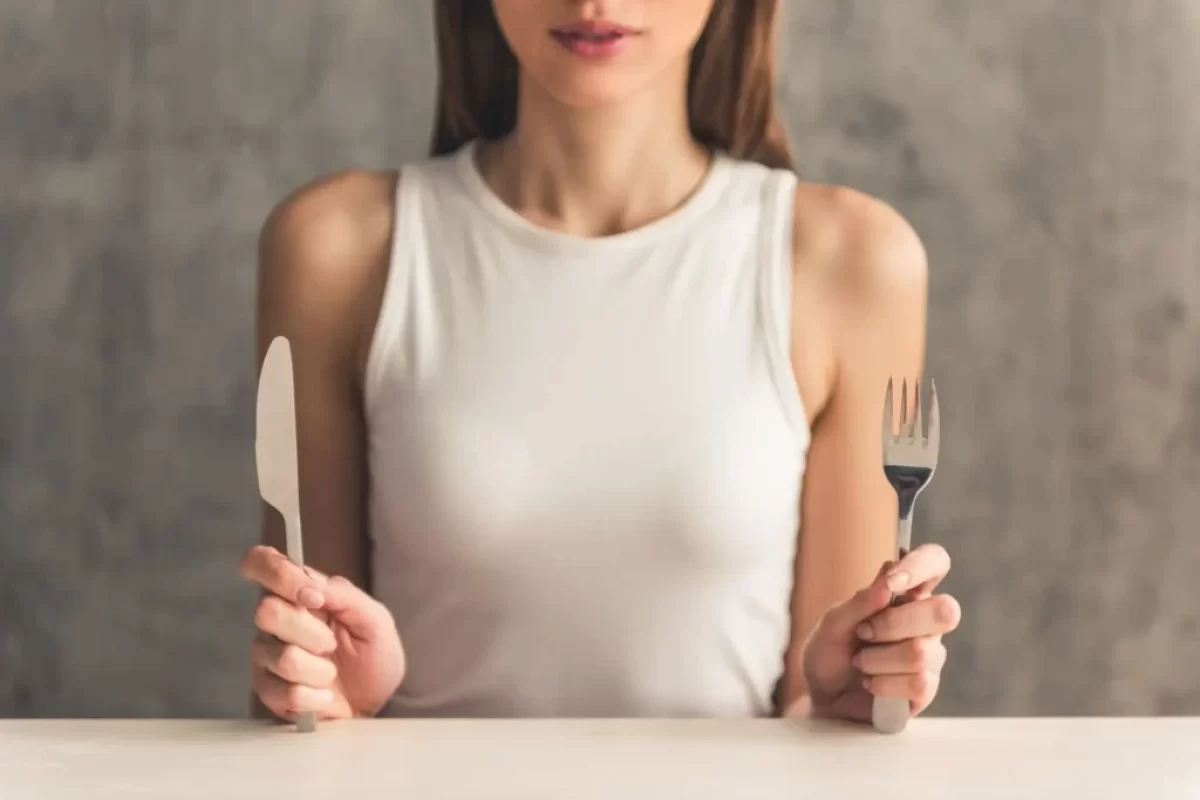 Žena sedí nad talířem