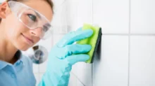 žena čistí spáry dlaždic houbičkou