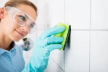 žena čistí spáry dlaždic houbičkou